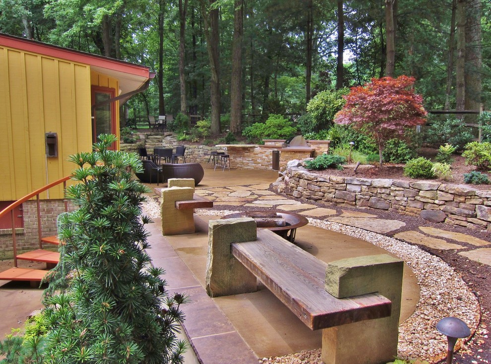 Design ideas for a mid-sized contemporary drought-tolerant and shade backyard stone retaining wall landscape in Other for summer.