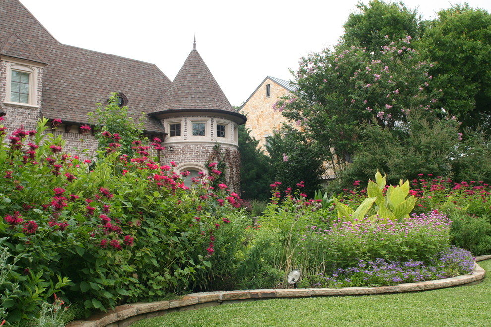 Photo of a large traditional full sun front yard brick formal garden in Dallas for summer.