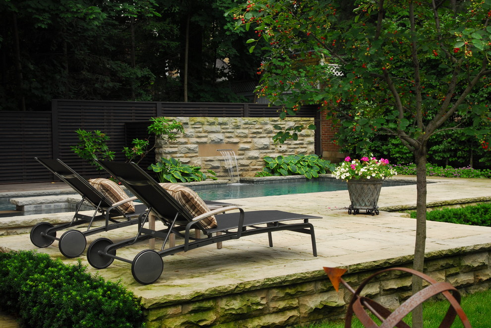 Diseño de jardín clásico de tamaño medio en verano en patio trasero con exposición reducida al sol, adoquines de piedra natural y fuente