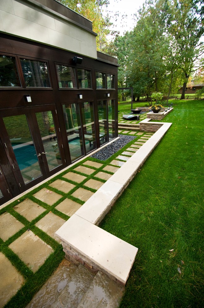Réalisation d'un jardin latéral design avec des pavés en pierre naturelle.
