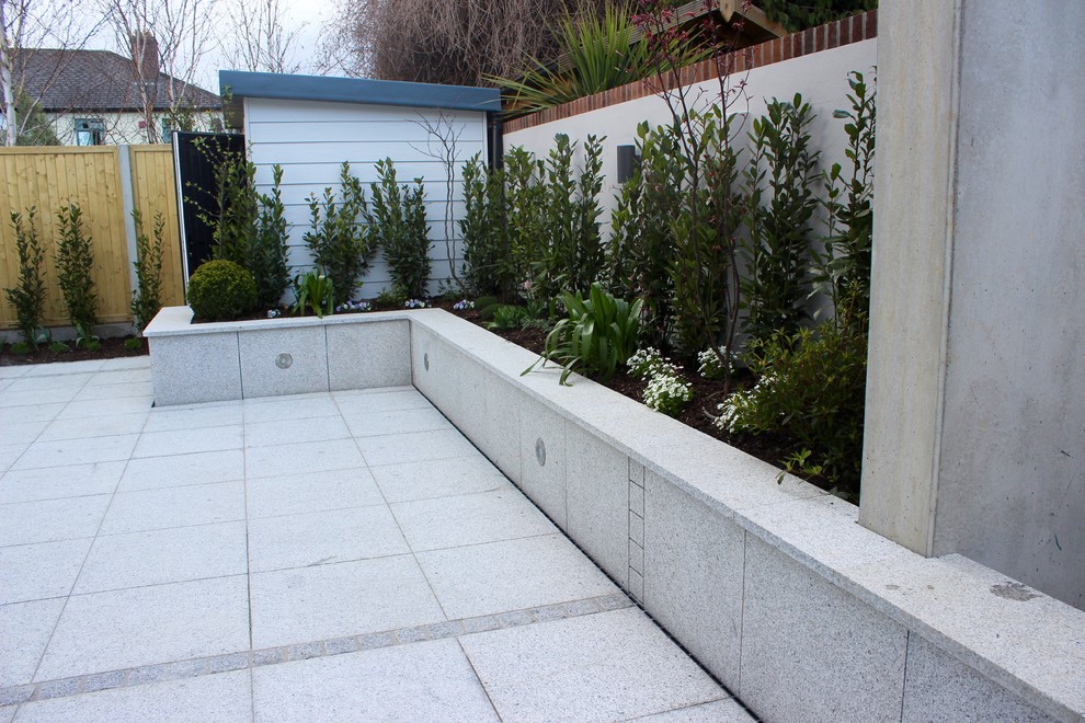Пример оригинального дизайна: солнечный, летний регулярный сад среднего размера на заднем дворе в современном стиле с высокими грядками, хорошей освещенностью, покрытием из каменной брусчатки и с деревянным забором