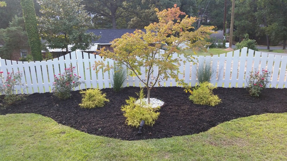 This is an example of a mid-sized traditional partial sun front yard mulch landscaping in Atlanta for summer.