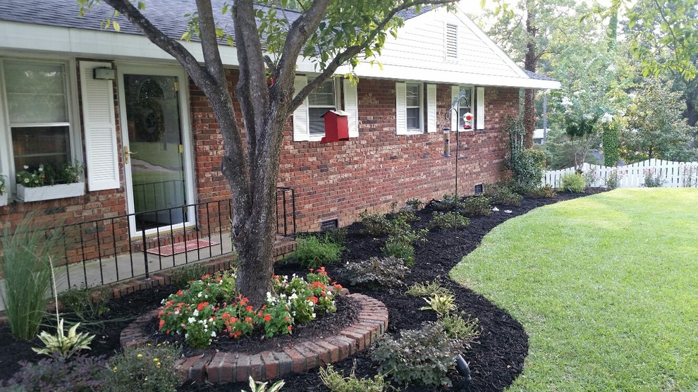 Photo of a mid-sized traditional partial sun front yard mulch landscaping in Atlanta for summer.