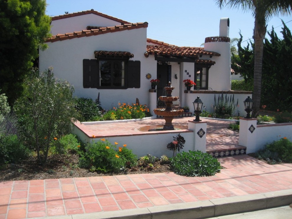 Photo of a mediterranean front fully shaded garden in Orange County with an outdoor sport court and concrete paving.