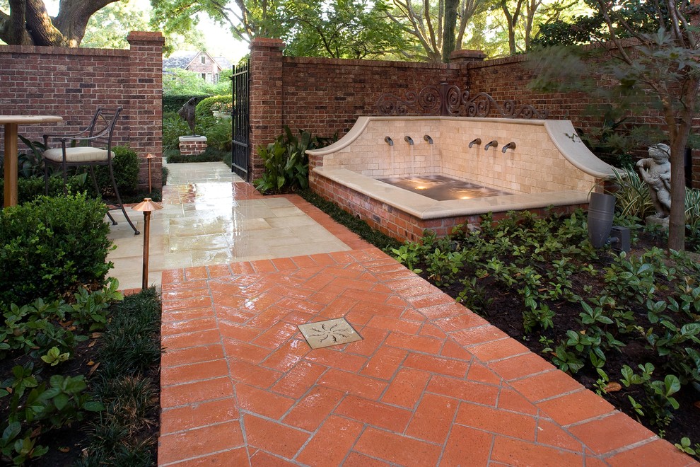 This is an example of a small classic courtyard fully shaded garden for autumn in Houston with a water feature and brick paving.