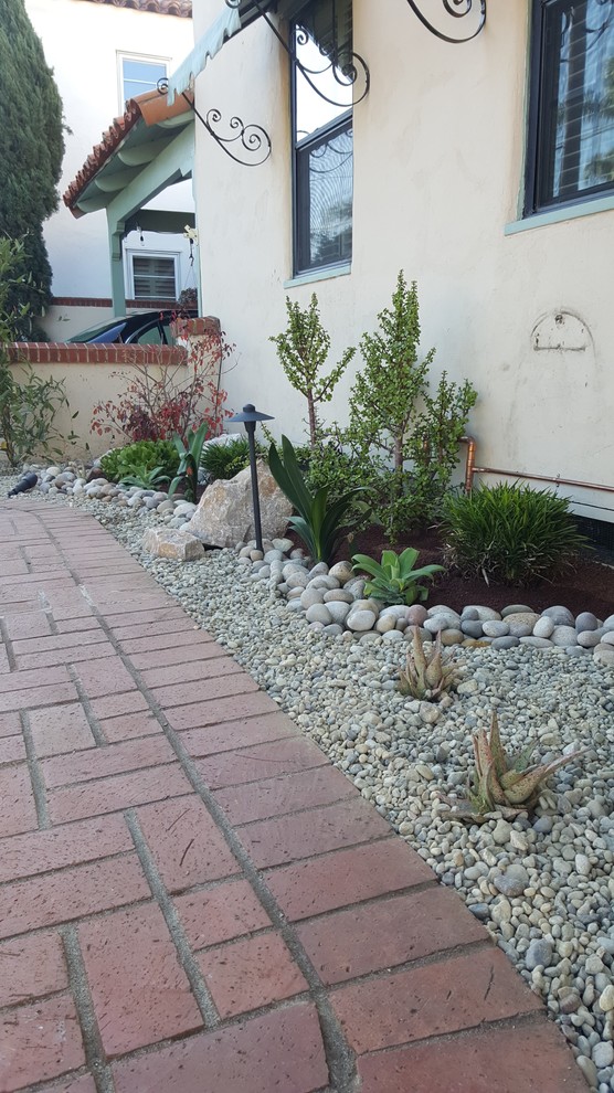 Пример оригинального дизайна: маленький засухоустойчивый сад на переднем дворе в средиземноморском стиле с полуденной тенью и покрытием из каменной брусчатки для на участке и в саду