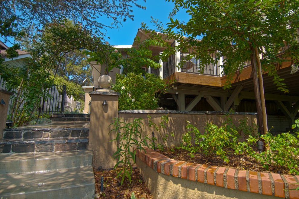 Esempio di un giardino boho chic in ombra di medie dimensioni e davanti casa in primavera con scale, pedane e recinzione in metallo
