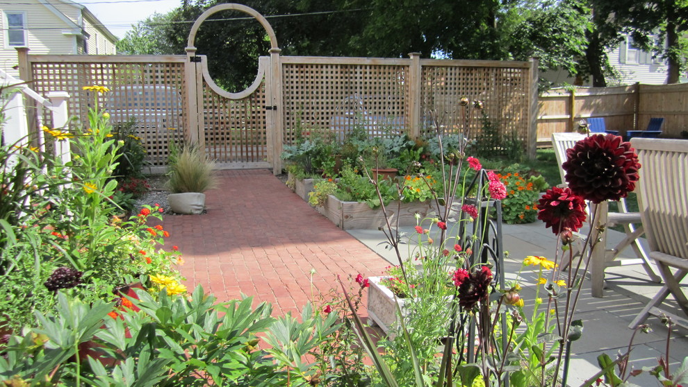 Cette image montre un petit jardin bohème l'été avec une exposition ensoleillée et des pavés en brique.