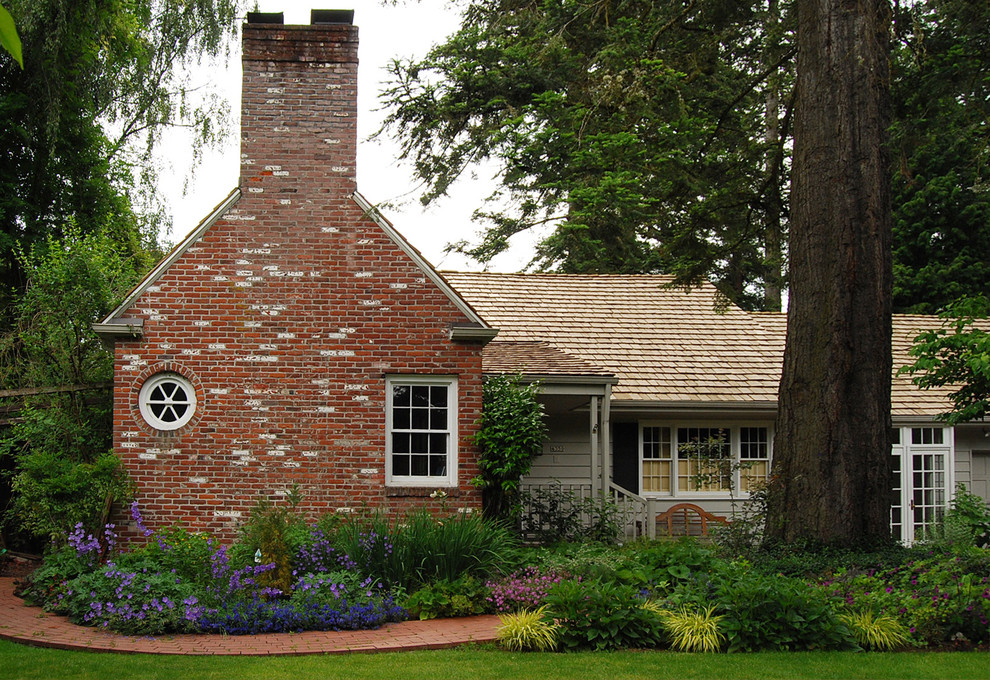 На фото: участок и сад на переднем дворе в классическом стиле с мощением клинкерной брусчаткой и клумбами