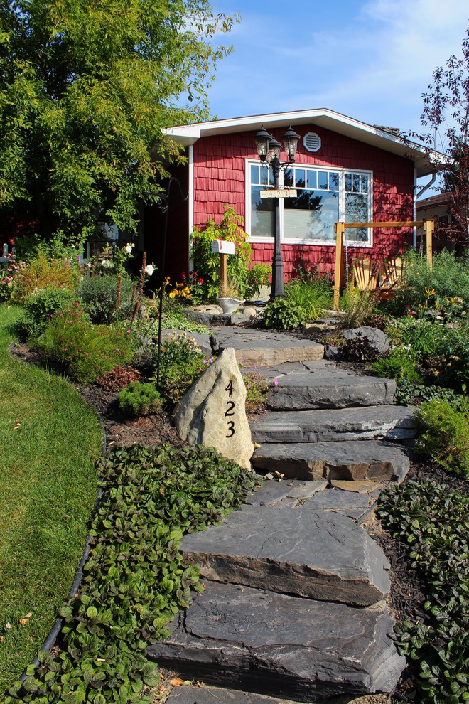 На фото: участок и сад на переднем дворе в классическом стиле с покрытием из каменной брусчатки и газонным бордюром с