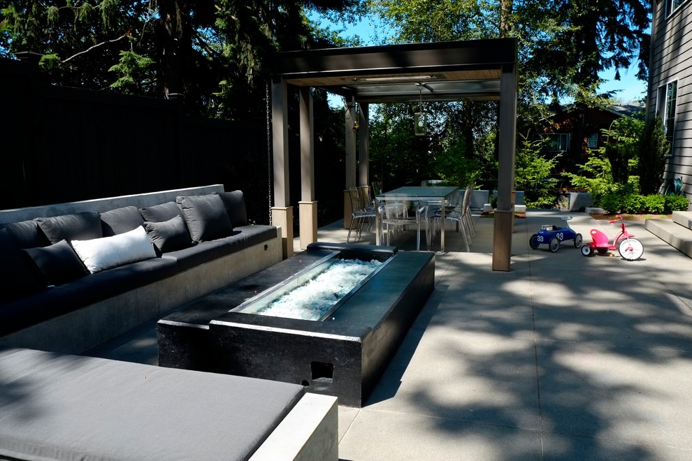 Diseño de jardín moderno de tamaño medio en patio trasero con jardín francés, brasero, exposición parcial al sol y adoquines de hormigón