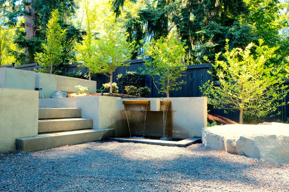 Idées déco pour un jardin à la française arrière moderne de taille moyenne avec un point d'eau, une exposition partiellement ombragée et des pavés en béton.