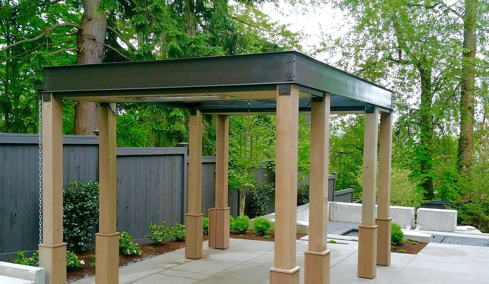 Photo of a medium sized modern back formal partial sun garden in Seattle with a fireplace and concrete paving.