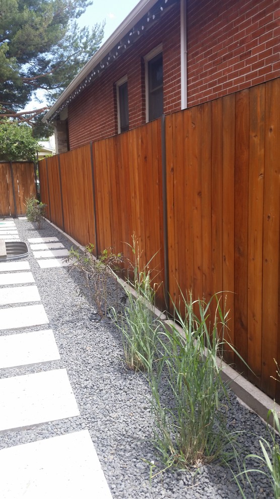 Exemple d'un petit aménagement d'entrée ou allée de jardin latéral tendance avec une exposition ensoleillée et du gravier.