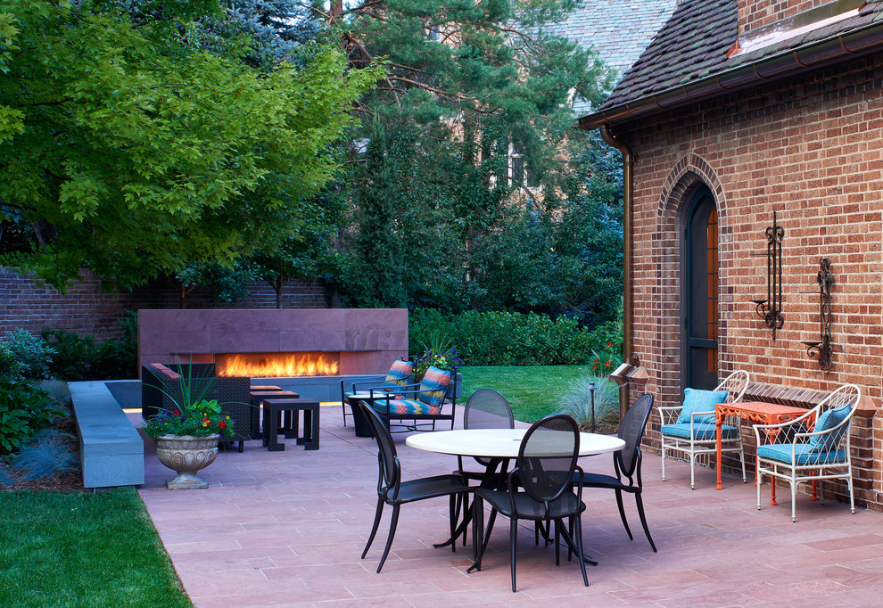 Idee per un patio o portico classico dietro casa e di medie dimensioni con pavimentazioni in pietra naturale e un caminetto