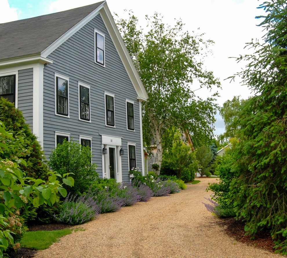 Photo of a mid-sized farmhouse partial sun front yard gravel driveway in Boston.