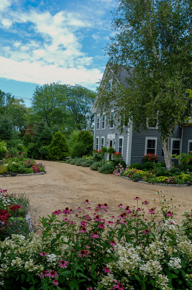 Design ideas for a mid-sized farmhouse full sun courtyard gravel driveway in Boston for summer.