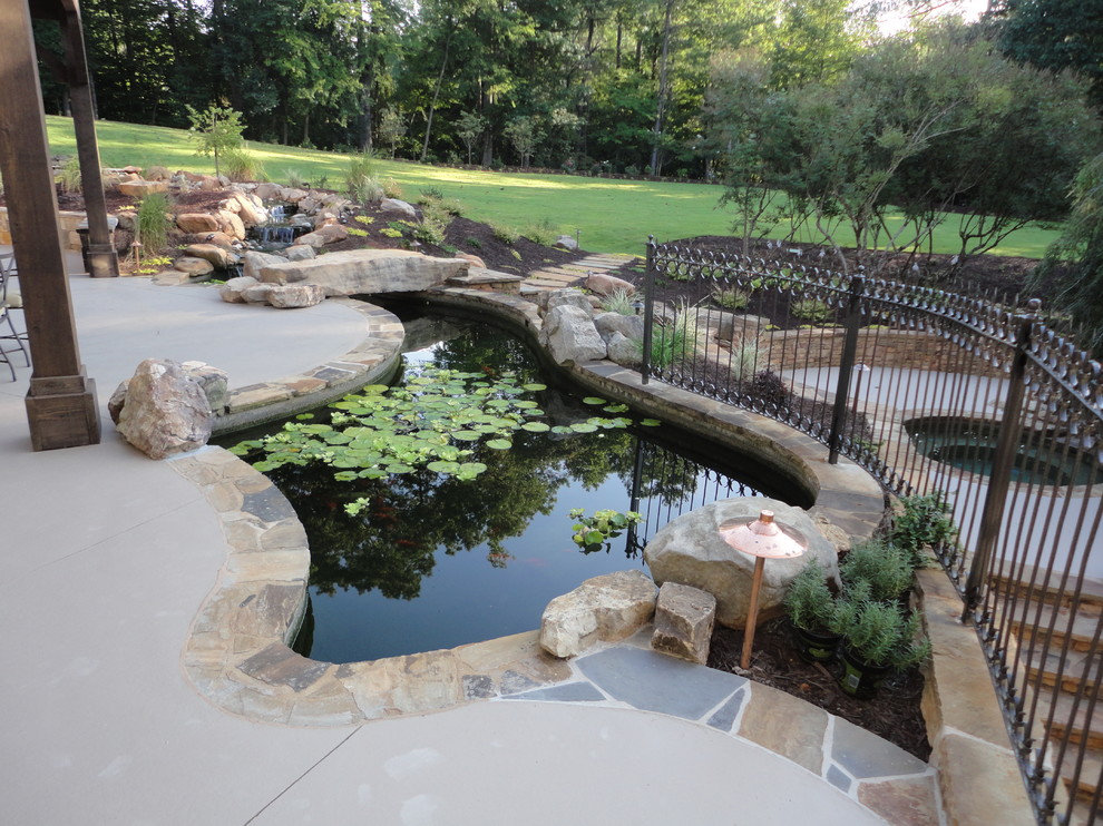 Design ideas for a mid-sized traditional partial sun backyard stone pond in Atlanta.