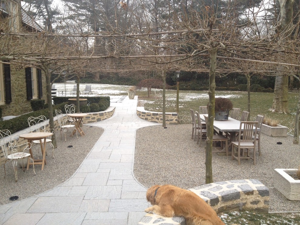 Diseño de jardín clásico grande en invierno en patio trasero con jardín francés, exposición total al sol y adoquines de piedra natural