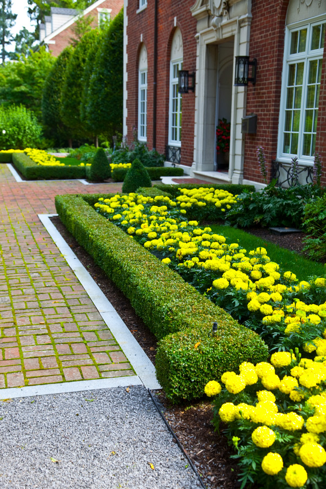 Esempio di un ampio giardino chic esposto in pieno sole davanti casa in primavera con un ingresso o sentiero e pavimentazioni in mattoni