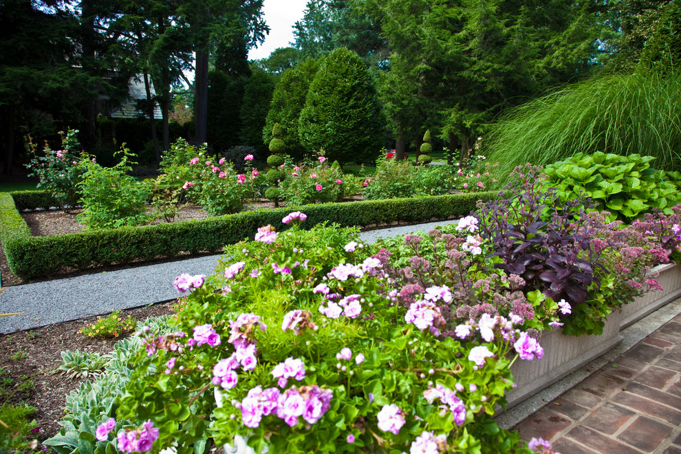 Ispirazione per un ampio giardino formale tradizionale esposto in pieno sole in cortile in primavera con un ingresso o sentiero e pacciame