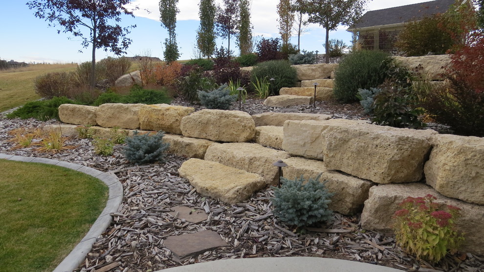 Photo of a large traditional backyard concrete paver landscaping in Calgary with a fire pit for fall.