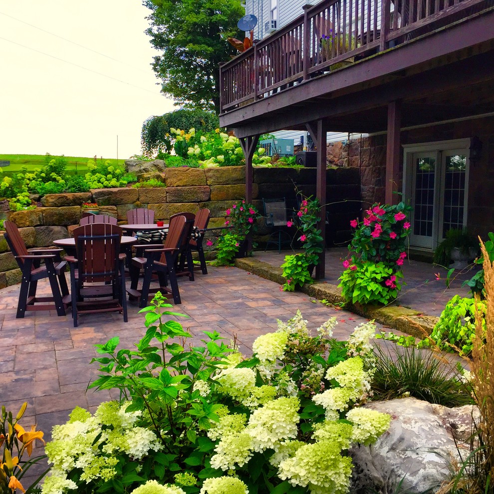 Foto de jardín de estilo de casa de campo de tamaño medio en verano en patio trasero con brasero, exposición parcial al sol y adoquines de hormigón