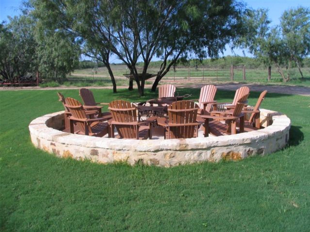 Design ideas for a large rustic full sun backyard mulch landscaping in Austin with a fire pit.