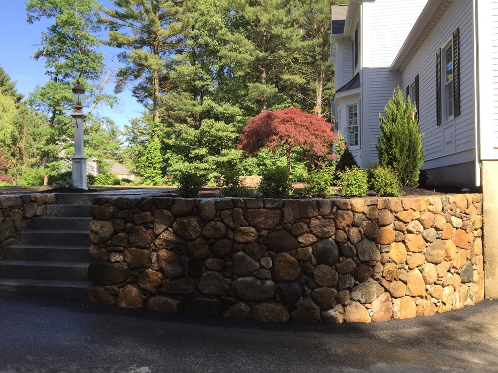 This is an example of a mid-sized traditional full sun side yard stone landscaping in Boston.