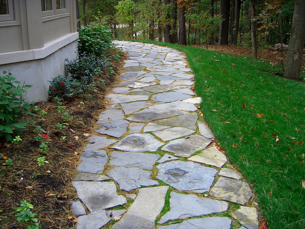 Inspiration for a mid-sized rustic side yard stone garden path in Toronto.