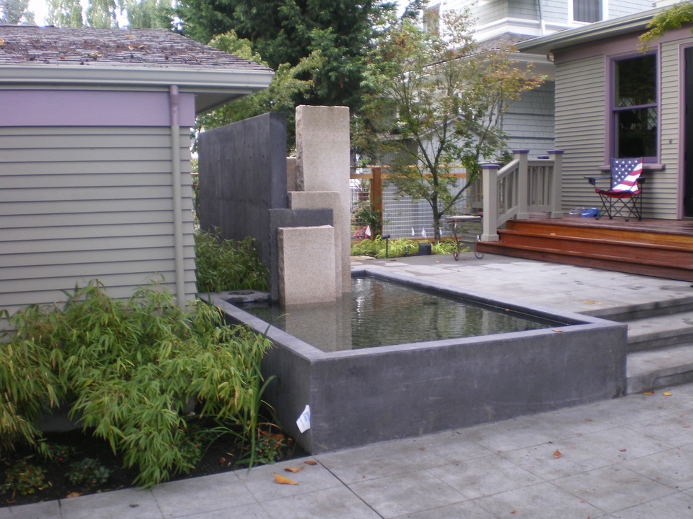 Mittelgroßer Moderner Gartenteich neben dem Haus mit direkter Sonneneinstrahlung und Betonboden in Seattle