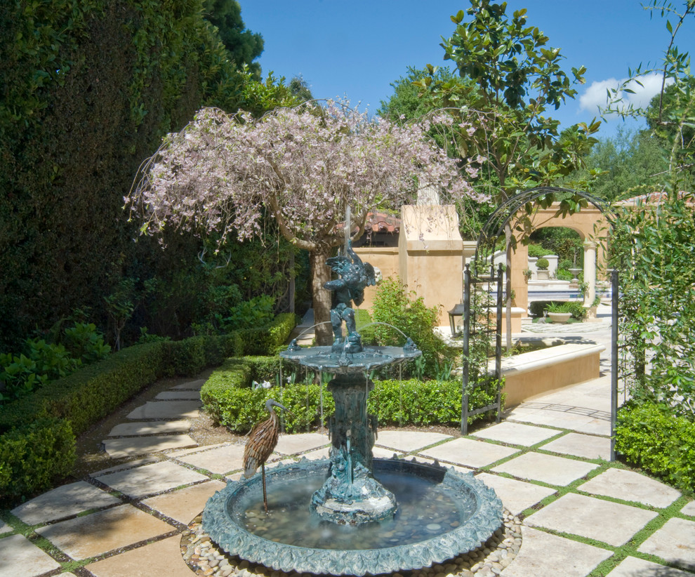 Foto de jardín tradicional grande en patio con fuente y adoquines de hormigón