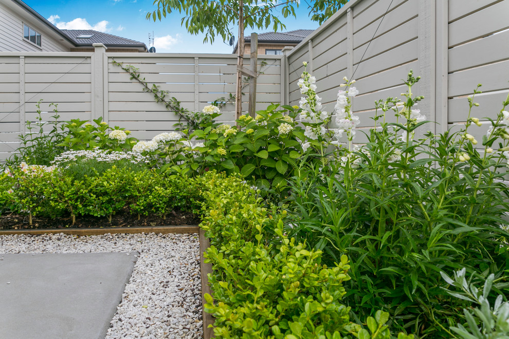 Idee per un piccolo giardino formale tradizionale esposto in pieno sole dietro casa in estate con un ingresso o sentiero e pavimentazioni in cemento