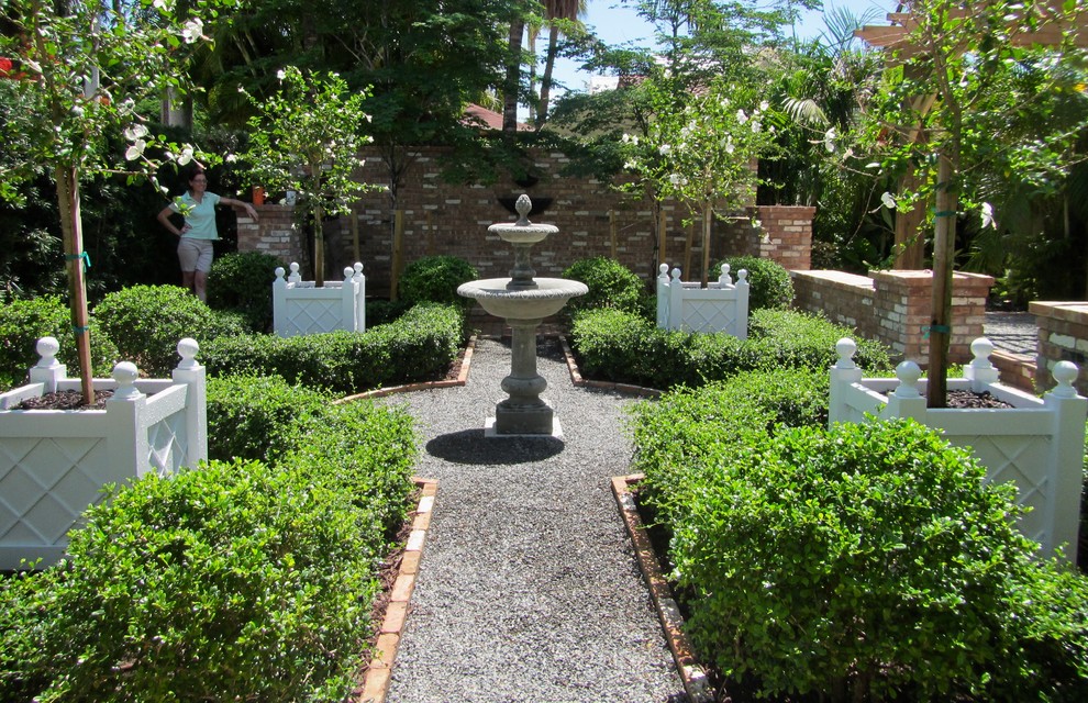 Ispirazione per un giardino formale tradizionale esposto in pieno sole di medie dimensioni e in cortile con un giardino in vaso e ghiaia