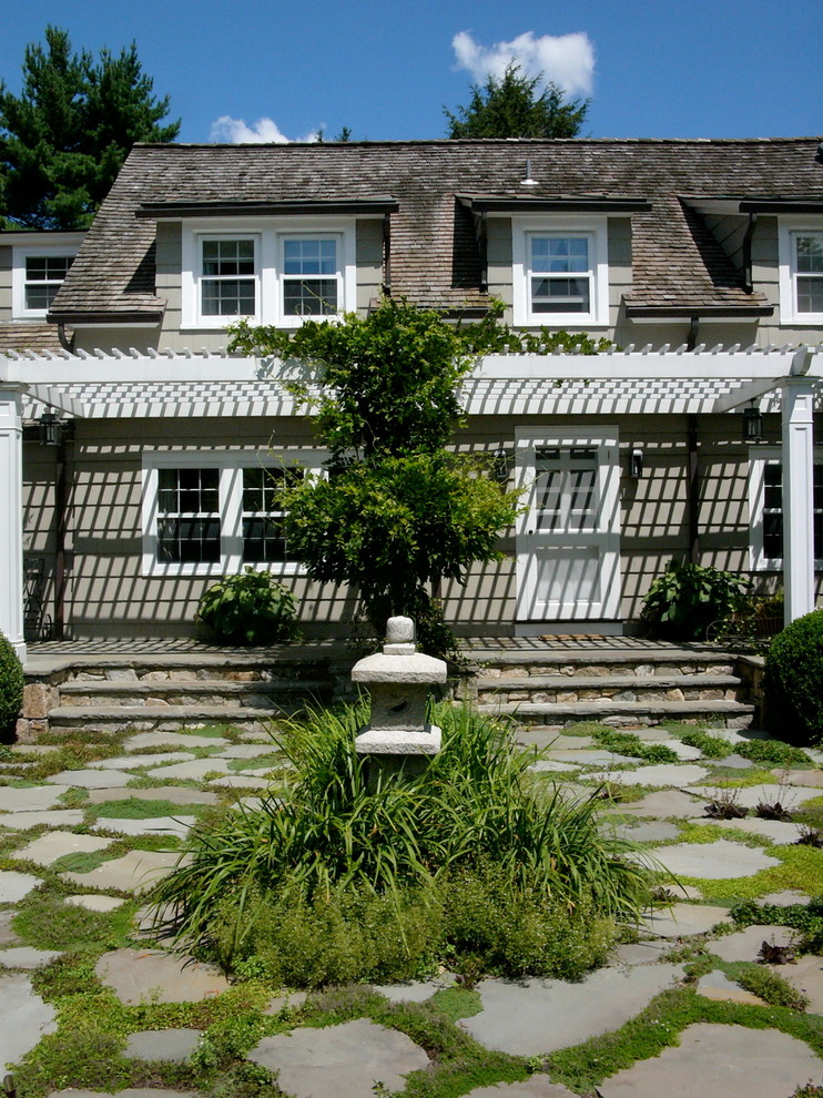 Inspiration for a large traditional front partial sun garden in New York with natural stone paving and a potted garden.