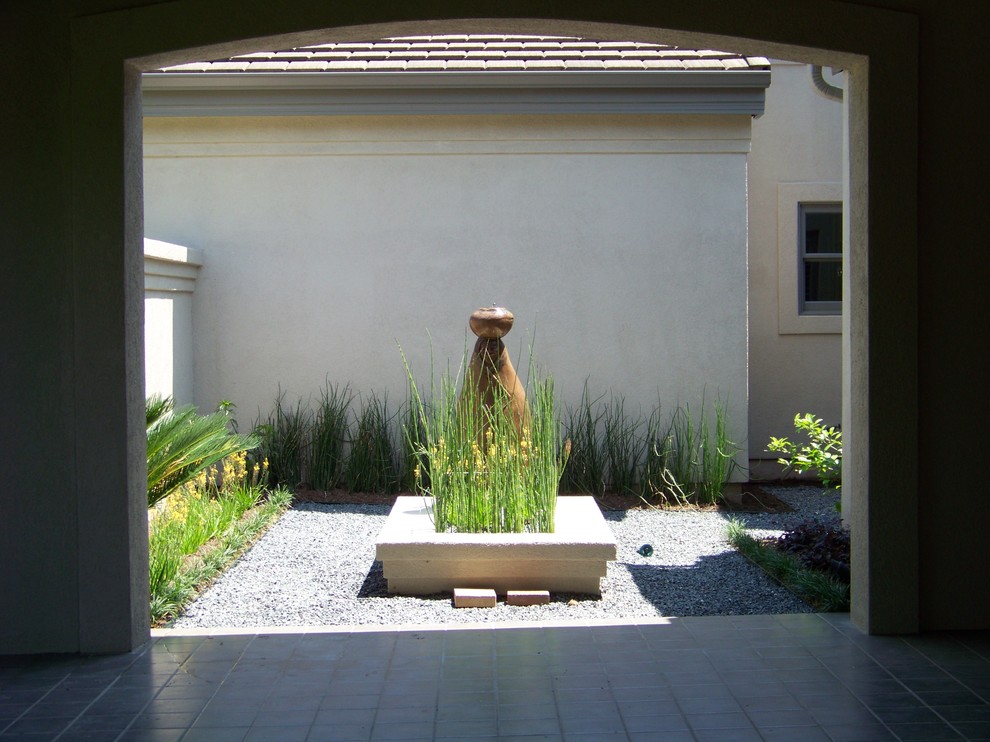 Imagen de jardín de secano minimalista pequeño en patio con fuente, exposición parcial al sol y gravilla