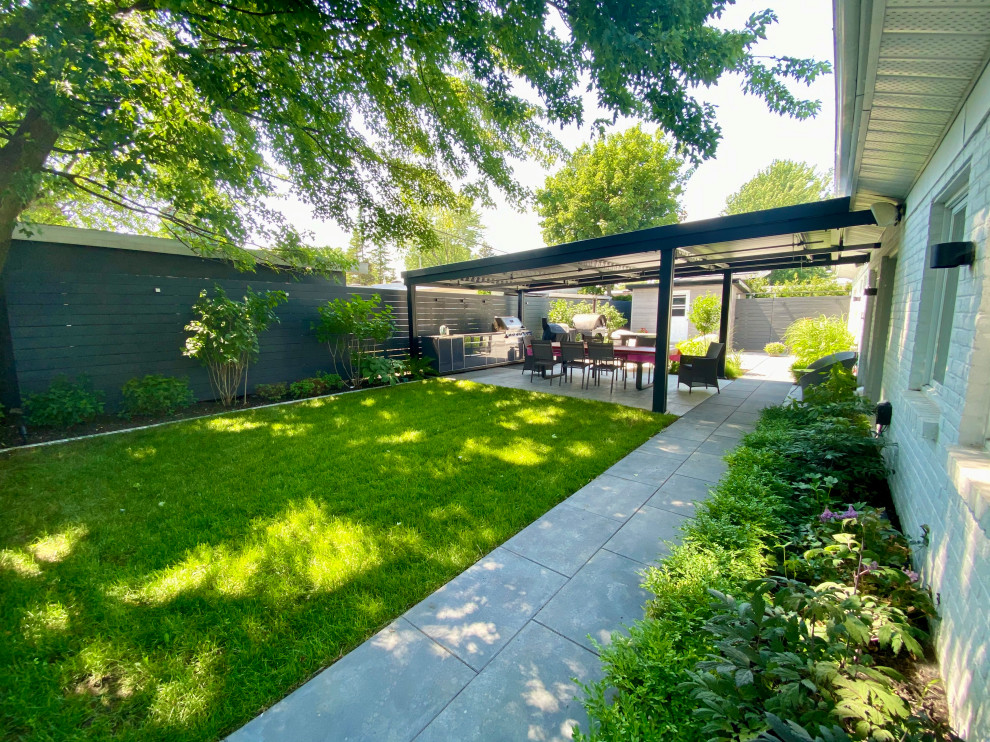Immagine di un giardino design esposto a mezz'ombra di medie dimensioni in estate con pavimentazioni in cemento