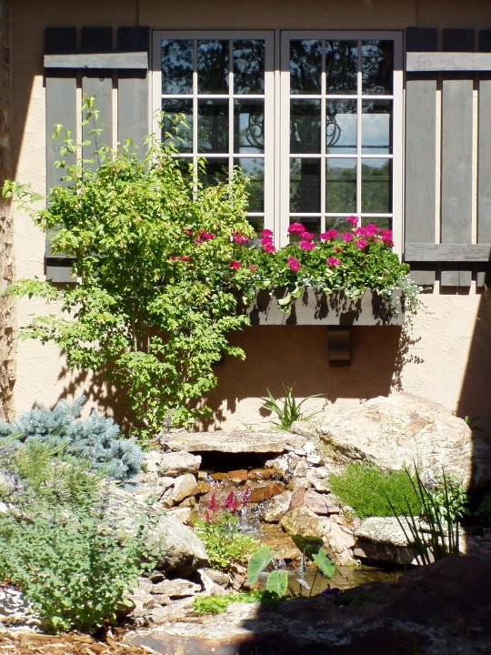 Diseño de jardín clásico en patio lateral con fuente