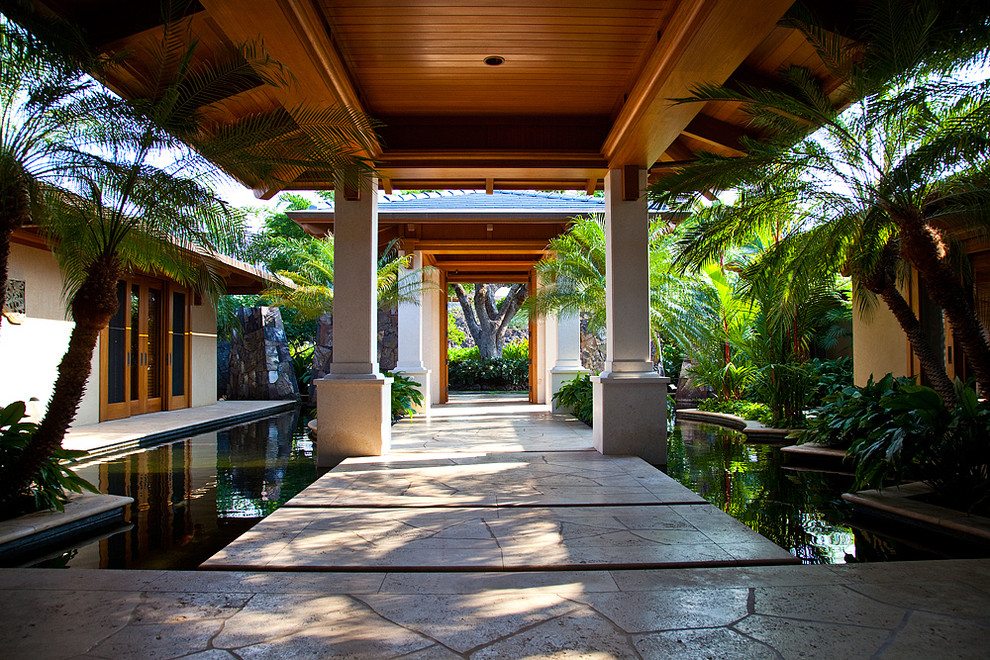 Diseño de jardín tropical de tamaño medio en patio con estanque, exposición parcial al sol y adoquines de piedra natural
