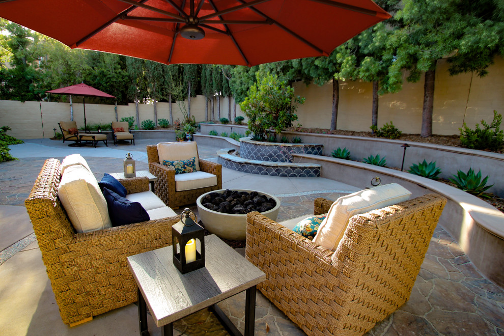 Medium sized mediterranean back patio in San Diego with a fire feature and concrete paving.