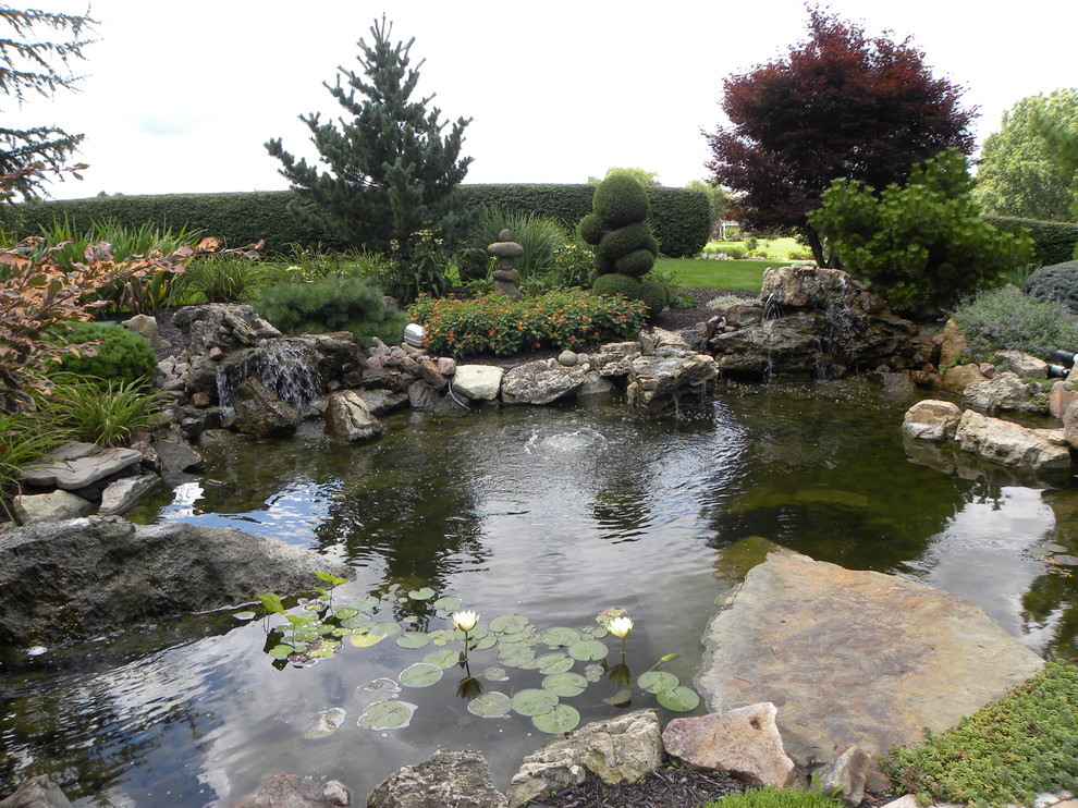 Esempio di un grande giardino classico esposto a mezz'ombra dietro casa in estate con fontane e pavimentazioni in pietra naturale