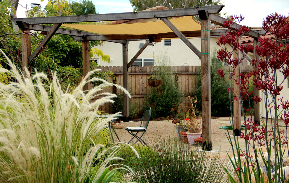 Стильный дизайн: засухоустойчивый сад среднего размера на заднем дворе в средиземноморском стиле с покрытием из гравия - последний тренд