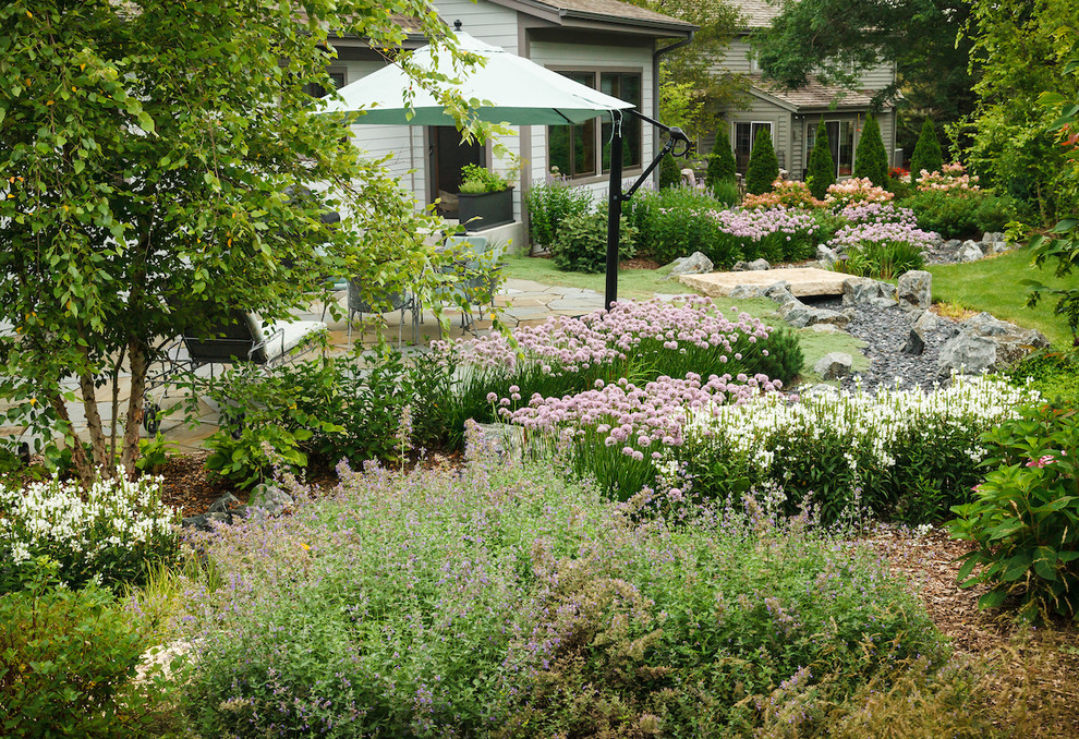 На фото: солнечный, летний участок и сад среднего размера на заднем дворе в стиле кантри с покрытием из каменной брусчатки и хорошей освещенностью