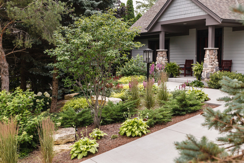 This is an example of a mid-sized craftsman partial sun front yard landscaping in Milwaukee for summer.