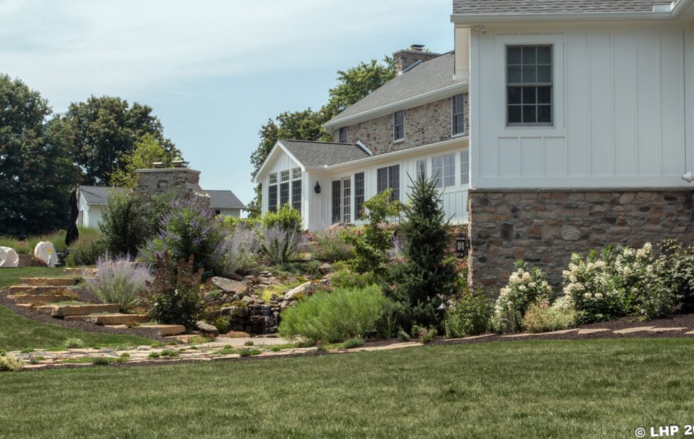 Design ideas for a large traditional full sun backyard stone landscaping in Columbus for summer.