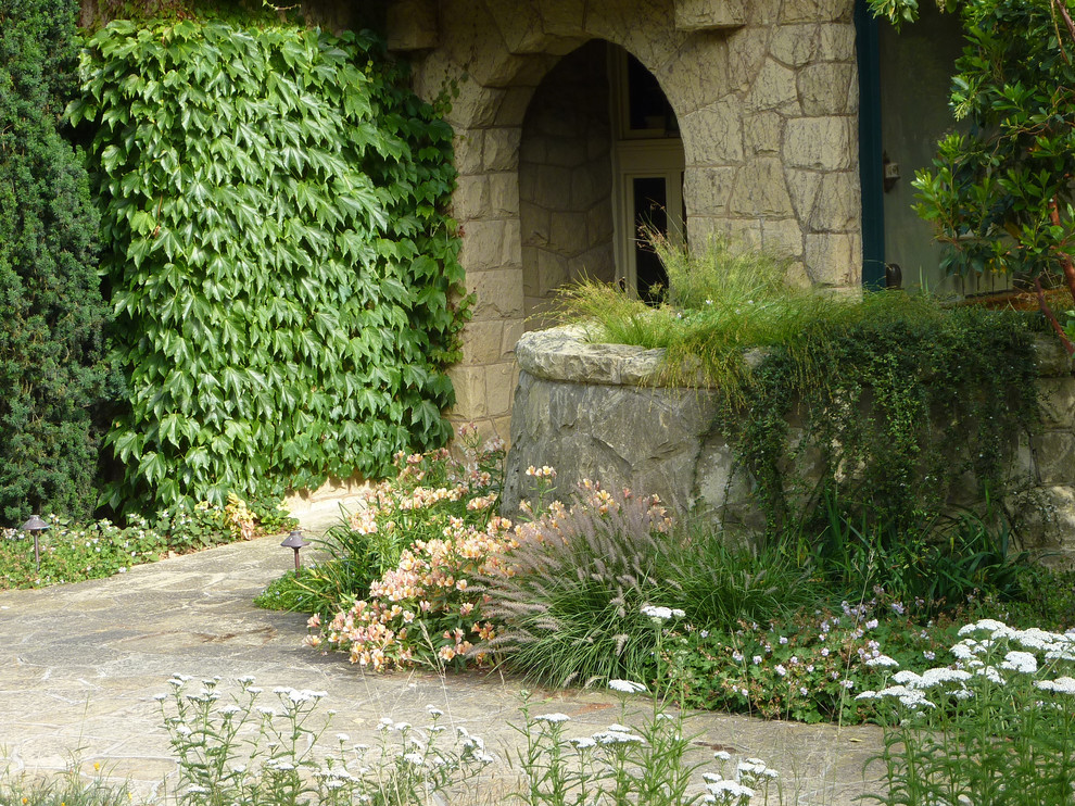 Ejemplo de jardín de secano de estilo americano grande en primavera en patio trasero con exposición total al sol y adoquines de piedra natural