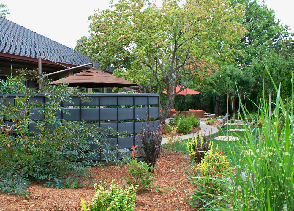 На фото: большой регулярный сад на заднем дворе в современном стиле с полуденной тенью и мощением тротуарной плиткой
