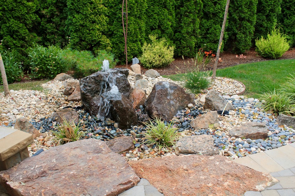 Cette photo montre un grand jardin arrière tendance l'été avec un point d'eau, une exposition partiellement ombragée et des pavés en béton.