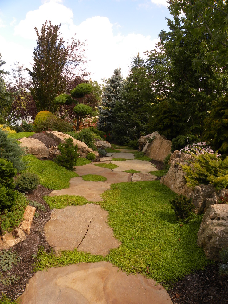 Immagine di un grande giardino classico in ombra nel cortile laterale in estate con un ingresso o sentiero e pavimentazioni in pietra naturale