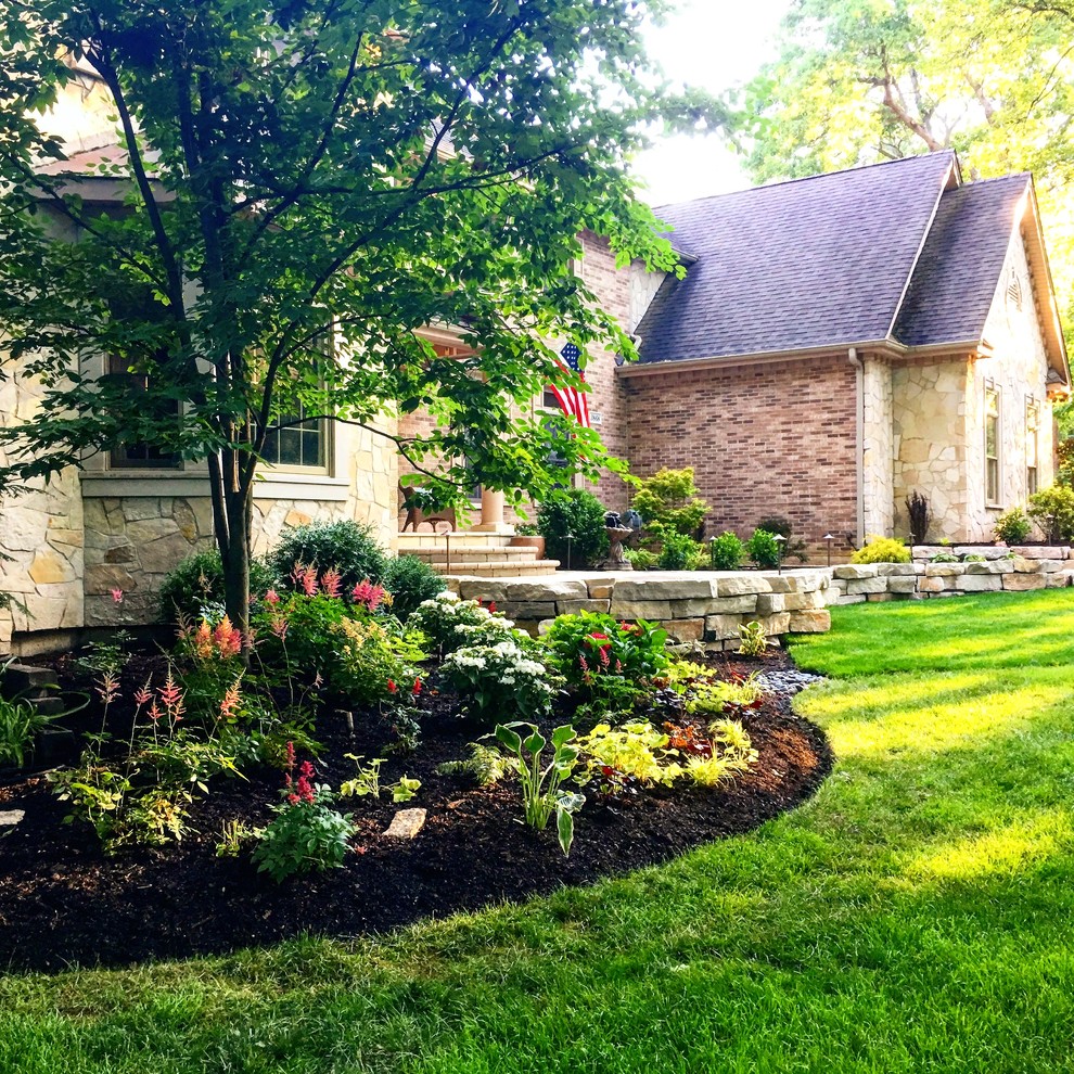 Inspiration for a large traditional partial sun front yard stone landscaping in Chicago for fall.